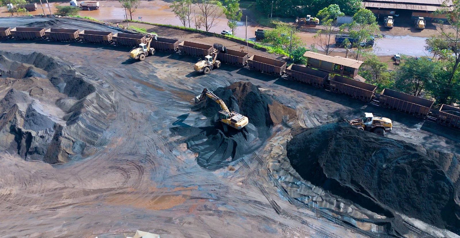Vista aérea do pátio com caminhões e composição ferroviária